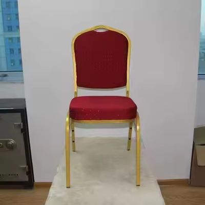 Eleganckie krzesła bankietowe do hotelu ze złotego metalu, z możliwością sztaplowania, z czerwonymi poduszkami z tkaniny, na przyjęcia weselne
